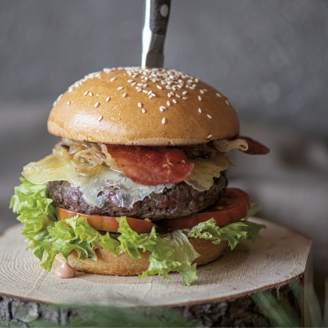 wild o’williams Seiser Alm – besondere Speisen mit Leidenschaft serviert WOW Burger auf einem Holzbrett serviert